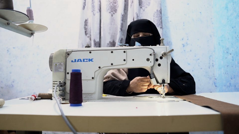 Women in Exile: a woman at her sewing machine