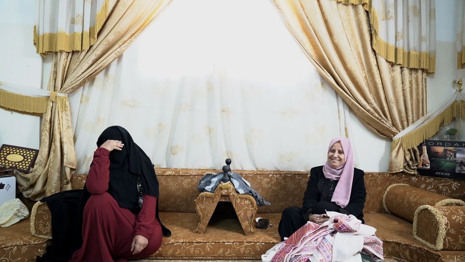 Women in Exile: two women with embroidered fabric