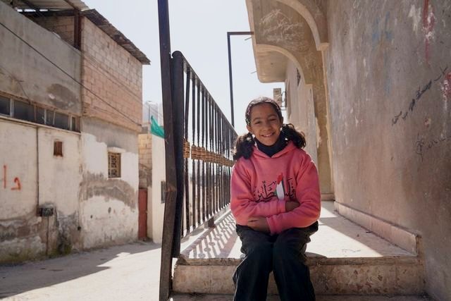 Women in Exile: a girl on a doorstep in the camp